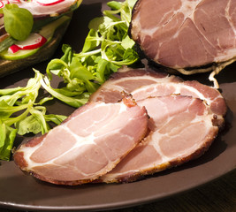  dried gammon ham with sandwich, salad on plate on wooden board