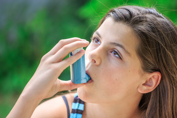 Portrait of a girl using asthma inhaler