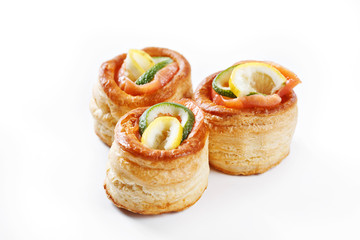 nice set of rolled pancake canapes with lemon, lime and salmon on white background studio isolated with space for text template