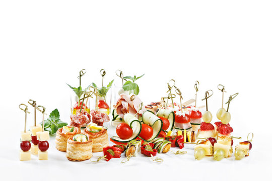 Fototapeta great attractive set of canapes with vegetables, cheese, fruits, berries, salami, seafood, meat and decoration on white background studio isolated with space for text template