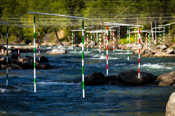 Gate of whitewater slalom over the rough river against the wood