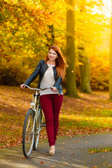 Fototapeta na wymiar Beauty girl relaxing in autumn park with bicycle, outdoor