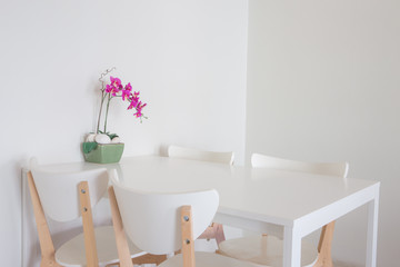 White empty dinning table set with chairs.