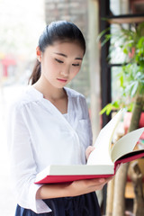 beautiful young woman with a book in cafe