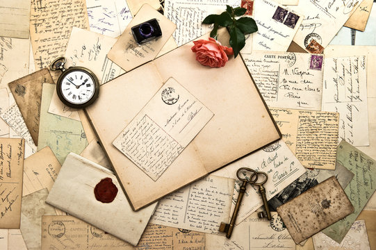 Open book, roses flower, old accessories and postcards