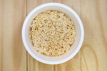 Instant noddles in white bowl on woods