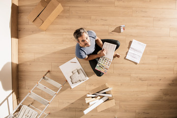 Top view, a modern man sitting on the floor of his new home