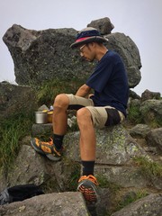 山頂で料理する男性