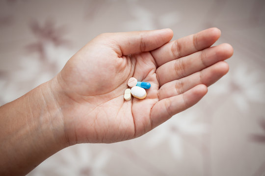 Closeup pills on woman hand