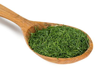 dried dill in a wooden spoon isolated