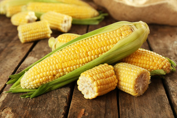 Fresh corn on cobs on rustic wooden table, closeup