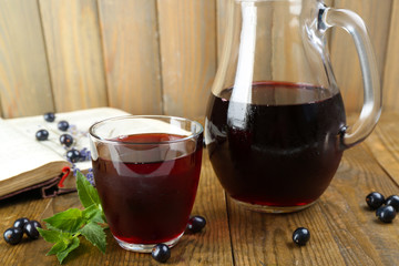 Fresh currant juice with berries and book on table close up