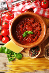 Pasta spaghetti with tomatoes, sauce bolognese, cheese and basil on rustic wooden  background