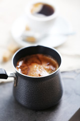 Turk of flavored coffee on table with napkin, closeup