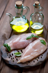 Raw fresh chicken breast fillets with seasonings and olive oil