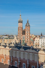 Obraz premium Krakow, Poland, Virgin Mary church on the Main Market Square seen over Sukiennice (Cloth Hall) from the Town Hall tower late afternoon