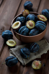 Ripe plums in a glass bowl, selective focus, studio shot