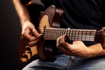 Obraz na płótnie Canvas Young musician playing electric guitar close up