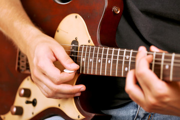 Fototapeta premium Young musician playing electric guitar close up