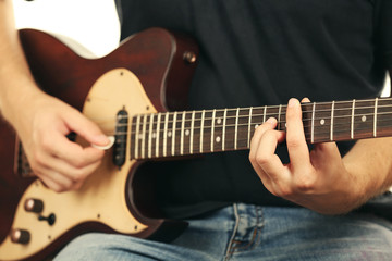 Fototapeta na wymiar Young musician playing electric guitar close up