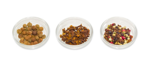 Three glass containers with allspice, mixture of peppers and clo