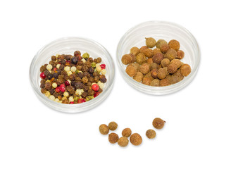 Two glass containers with mixture of peppers and allspice