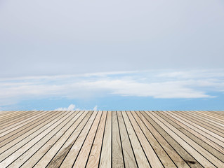 Wood plank over blurred clouds sky background