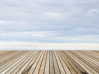 Wood plank over blurred clouds sky background