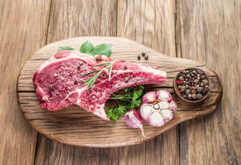 Raw beef steaks with spices on a white background.