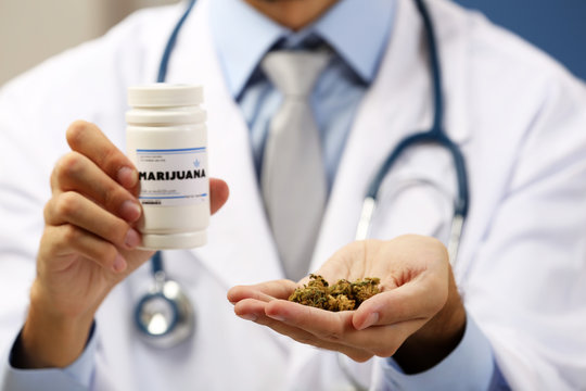 Doctor holding bottle with medical cannabis close up