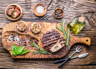 Beef steaks  with spices on a wooden tray.