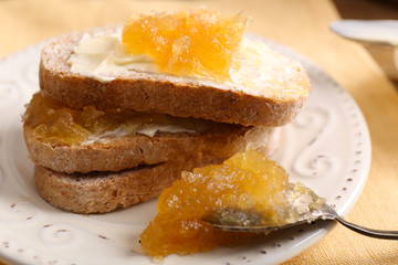 Fresh toast with butter and jam on table close up