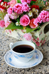 Cup of coffee and blur flower background.