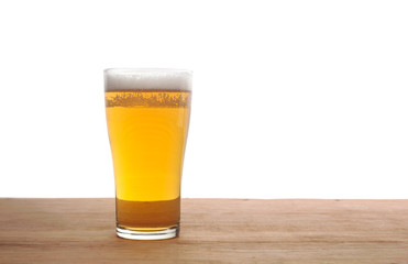 Glass of beer on wooden bar isolated