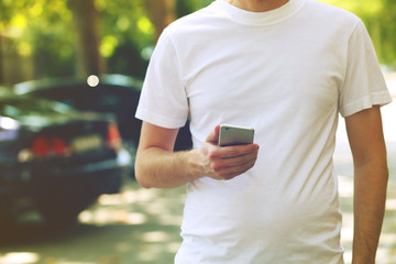 Man holding smart mobile phone outdoors