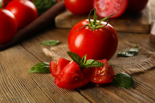 Red tomatoes on napkin on wooden background