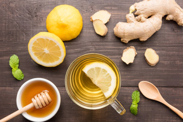Naklejka na ściany i meble Cup of ginger tea with lemon and honey on wooden background