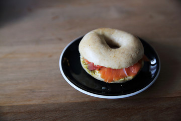 Smoked salmon bagel on wood background