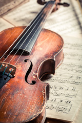 Fototapeta premium Old musical sheets and violin on old wooden table