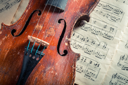 Old violin and musical sheets on old wooden table