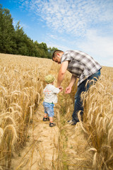 man walking with his kid in the field 
