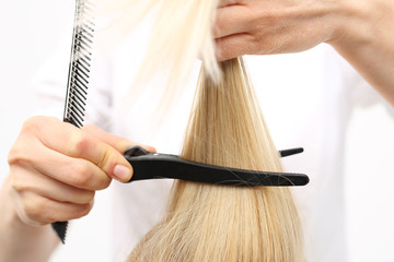 Naklejka premium Kobieta na fotelu fryzjerskim podczas zabiegu stylizacji włosów