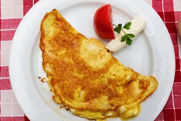 Scrambled eggs with cheese and tomato. Tasteful breakfast for one person. Top view.