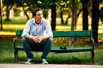 handsome adult man sitting on bench - Powered by Adobe