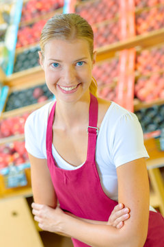 Smiling shop assistant in grocery store