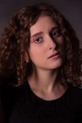 Fototapeta premium Portrait of red-haired young woman in a low key