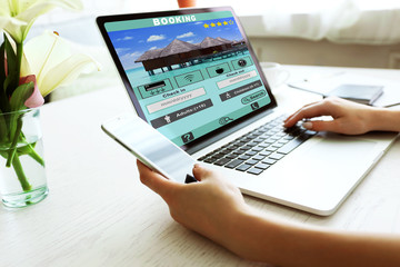 Fototapeta na wymiar Woman using laptop to book hotel online