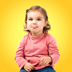 Cute baby girl sticking out tongue over white background