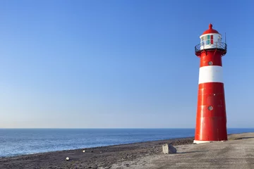 Wallpaper murals Lighthouse Red and white lighthouse and a clear blue sky