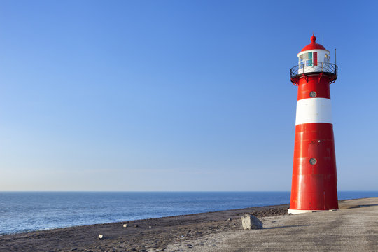 Red and white lighthouse and a clear blue sky